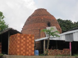 A family run brickworks in the Mekong Delta. Bricks are stacked in front and the beehive kiln - just like those used in Regency England, can be seen behind.
