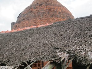 A Mekong Delta family run brick-works; the thatched brick storage are in the foreground and the beehive kiln behind.